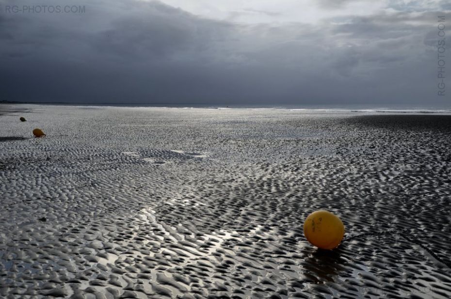 Trois boues sur le sable  mare basse sous un ciel d'orage