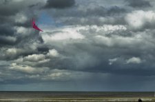 Cerf volant rose sur fond de ciel gris menaant